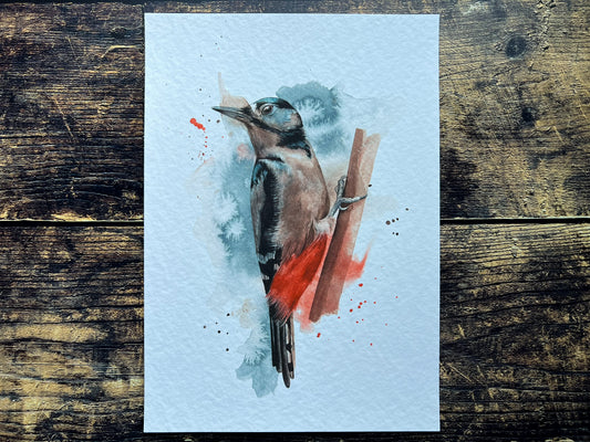 An A4 print of a great spotted woodpecker on textured archival paper.