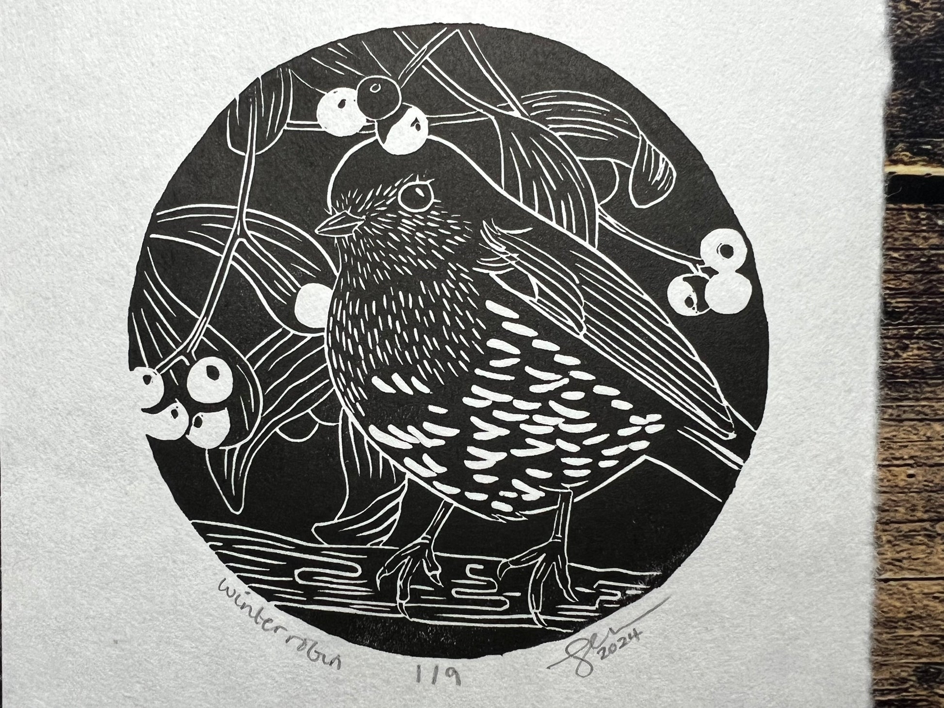 An A5 lino print of a robin surrounded by mistletoe