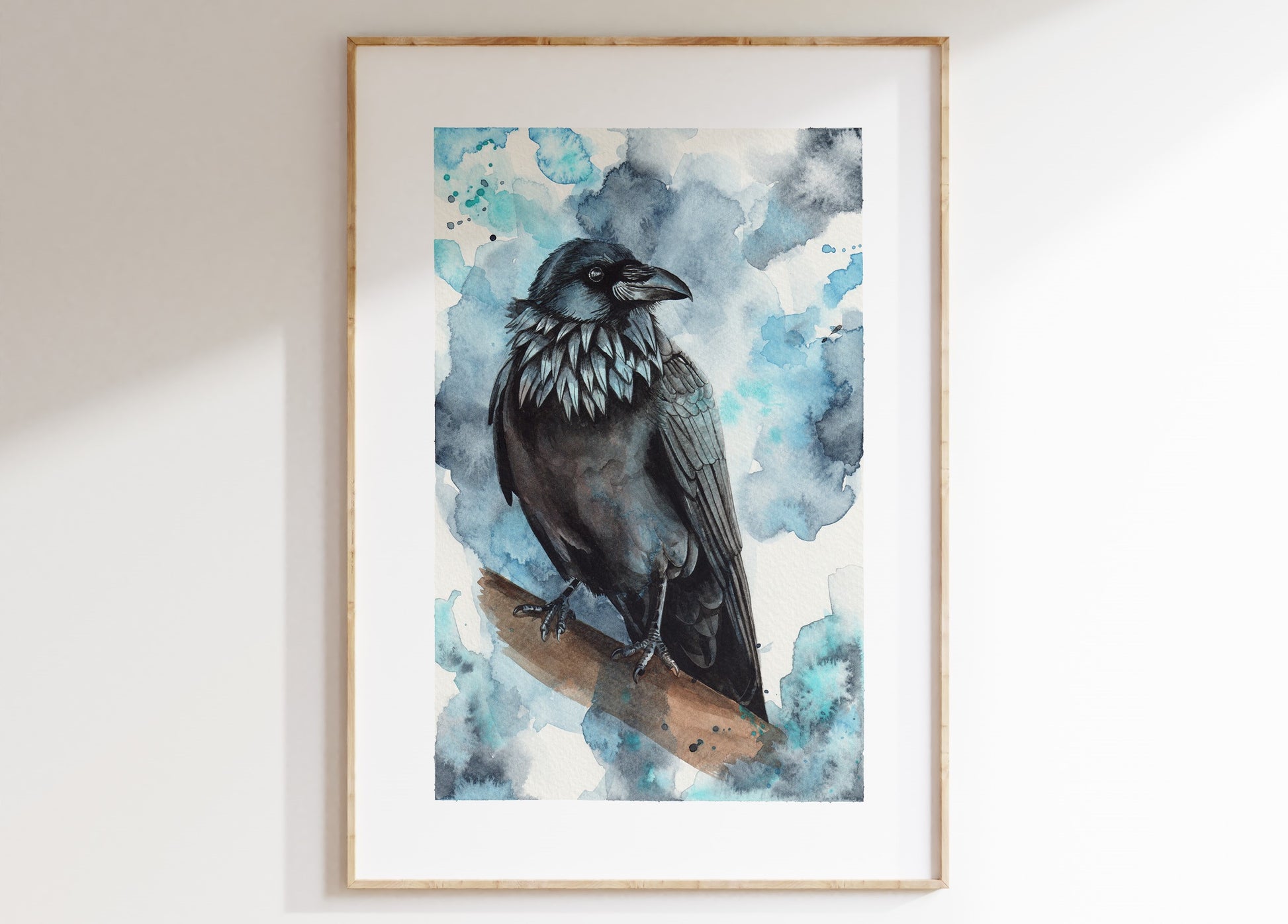 A watercolour print of a raven, mocked up into a frame